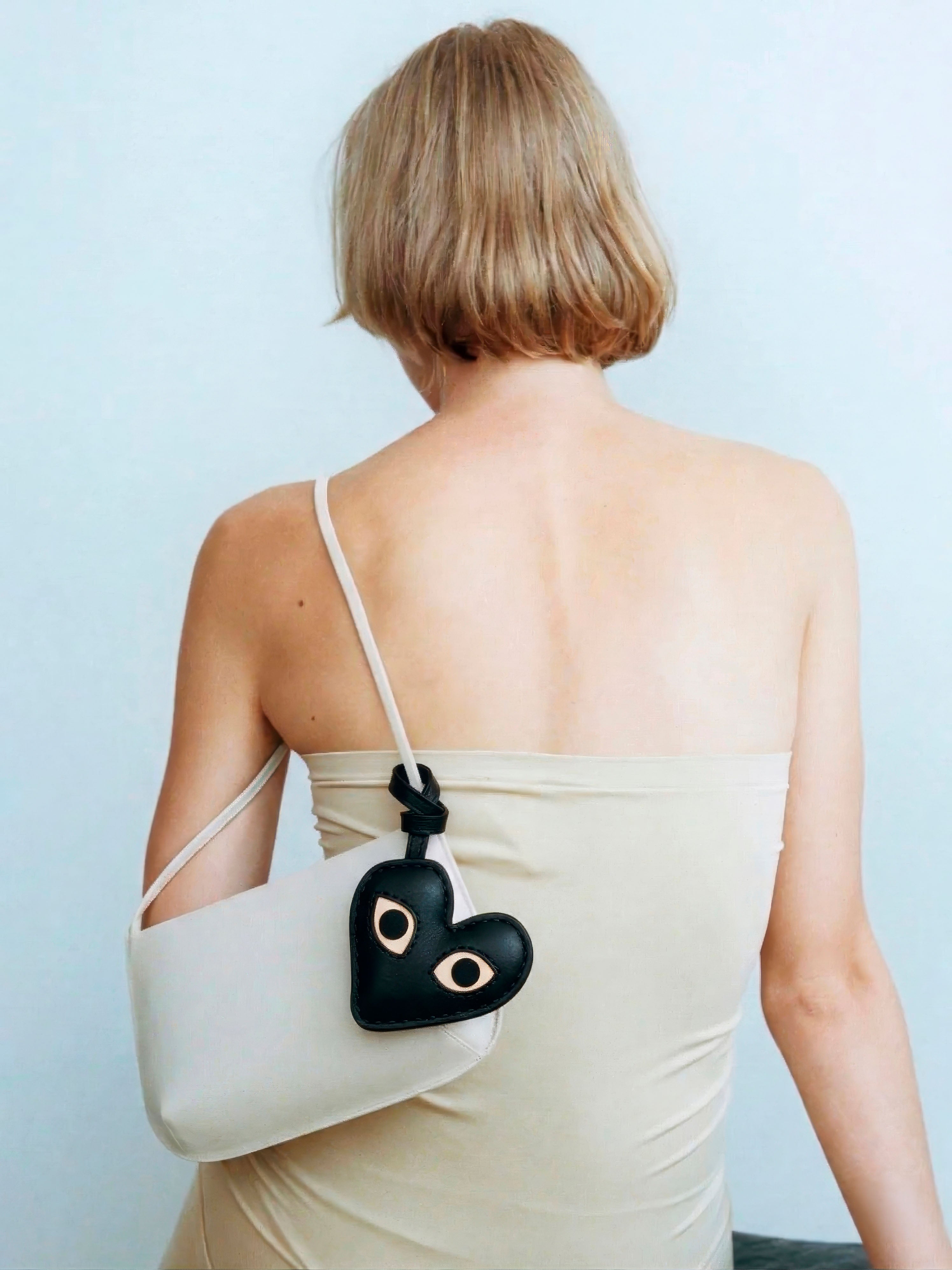 Bag Charm Coração com Olhos preto preso a bolsa em close - Charmme Brasil
