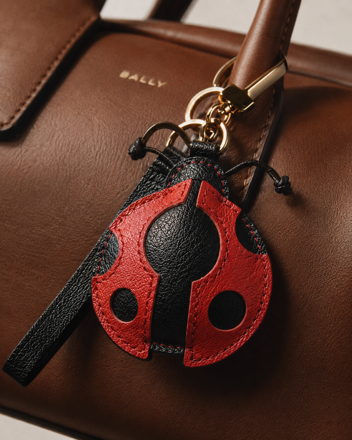 Bag Charm Joaninha em uso com bolsa - Charmme Brasil
