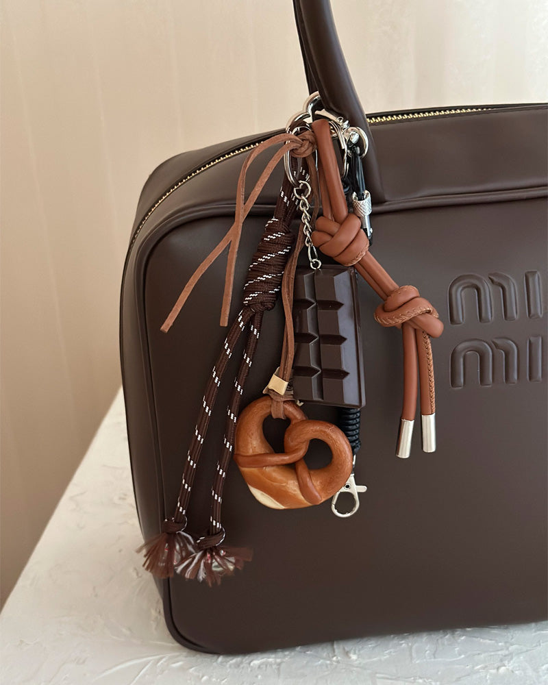 Bag Charm ChocoPretzel preso a bolsa em close - Charmme Brasil