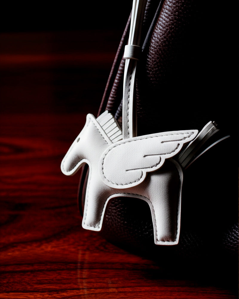 Bag Charm Pegasus branco preso a bolsa em close - Charmme Brasil